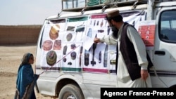 FILE - This picture taken on Nov. 9, 2021 shows a teacher from the HALO (Hazardous Area Life-Support Organization) Trust educating children about mine risks in Nad-e-Ali village in Helmand province.