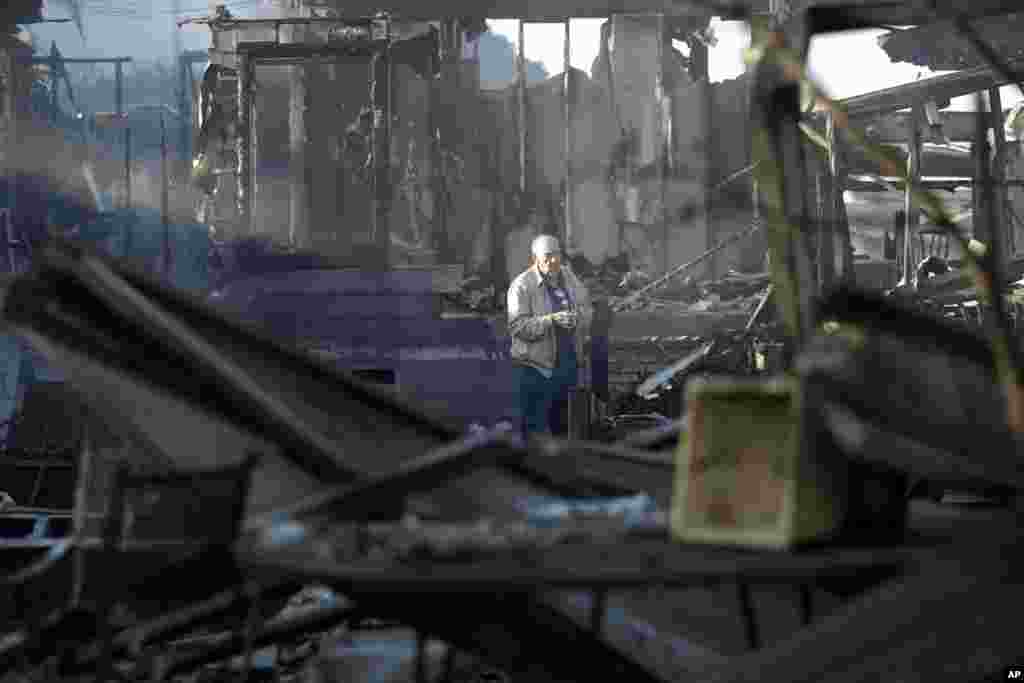 Dick Marsala looks through debris from his destroyed home after a wildfire roared through the Rancho Monserate Country Club, Dec. 8, 2017, in Bonsall, California. 