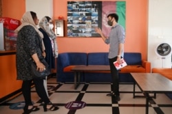 A teacher talks with students at a coffee shop in the Kardan University in Kabul, June 15, 2021.