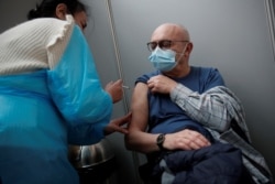 An elderly visitor receives a dose of the Pfizer-BioNTech COVID-19 vaccine at the Cent Quatre cultural center in Paris, France, Feb. 1, 2021.