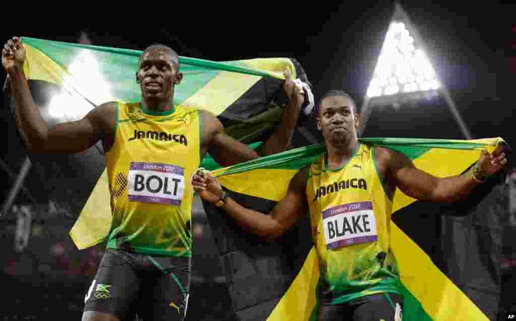 Usain Bolt celebrates winning gold alongside silver medalist Yohan Blake, both of Jamaica, following the men&#39;s 100-meter final.