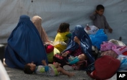 Afghan refugee families wait at the office of United Nations High Commissioner for Refugees to register to go back to Afghanistan, in Peshawar, Pakistan, April 27, 2017.