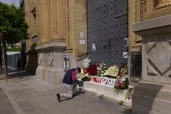 A man prays in front of the main gate of La Sed church after an Easter Holy Week procession was canceled due to the coronavirus outbreak in Seville, Spain, April 9, 2020.