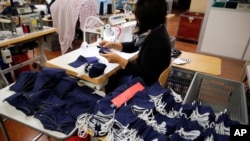 An employee sews face protective masks in Chanteclair Hosiery, a French knitwear clothing manufacturer in Saint Pouange, east of Paris, on June 12, 2020.