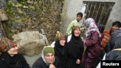 Relatives mourn Ikrama Abkour, whom activists say was killed in a Syrian Air Force missile attack, near Homs, Dec. 21, 2012.