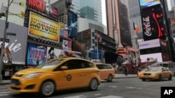 FILE - New York City taxis pass through New York's Times Square.