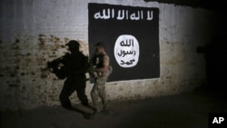 Arhiv, ilustracija - Irački vojnik istražuje tunel ispred grafita sa zastavom terorističke grupe Islamska država.