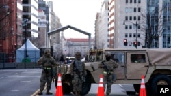 Members of the National Guard secure a checkpoint in downtown Washington, ahead of President-elect Joe Biden's inauguration ceremony, Jan. 18, 2021.