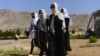 Afghan girl students cover their faces with scarfs as they walk inside the compound of their school after it was reopened, which was earlier closed due to the COVID-19 coronavirus pandemic, in Herat on Aug. 23, 2020.