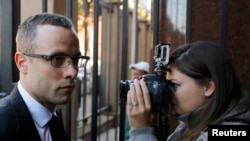 FILE - Olympic track star Oscar Pistorius (L) arrives ahead of his trial for the murder of his girlfriend Reeva Steenkamp, at the North Gauteng High Court in Pretoria, May 13, 2014.
