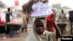 Girl hawks drinking water packed in sachets along street after days of religious clashes in the northern Nigerian city of Maiduguri, Aug. 4, 2009.