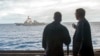 FILE - U.S. Secretary of Defense Ash Carter (R) speaks with U.S. Navy Cmdr. Robert C. Francis Jr., as Carter and Malaysian Defense Minister Hishammuddin Hussein (Not Pictured) visited the USS Theodore Roosevelt aircraft carrier in the South China Sea.