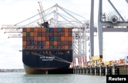 FILE - Shipping containers are stacked on a cargo ship in the dock at the ABP port in Southampton, Britain, Aug. 16, 2017.