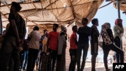 Eritrean refugees queue during a distribution of items organized the UNHCR at Mai Aini Refugee camp, in Ethiopia, Jan. 30, 2021.