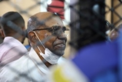 FILE - Sudan's ousted president Omar al-Bashir sits at the defendant's cage during his trial, at a courthouse in Khartoum, Sudan, Sept. 15, 2020.