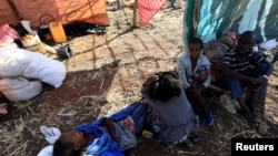 Ethiopian refugees who fled Tigray region, sit inside a makeshift shelter within the Um-Rakoba camp in Al-Qadarif state, on the border, in Sudan, Dec. 11, 2020.