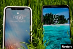 FILE - An Apple iPhone X, left, and a Samsung Galaxy S9 Plus mobile phone are displayed during a preview in New York, Feb. 21, 2018.