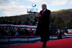 President Donald Trump applauds during a campaign rally at Keith House-Washington's Headquarters in Newtown, Pa., Oct. 31, 2020.