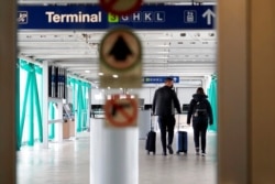 FILE - Travelers walk through O'Hare International Airport in Chicago, Nov. 29, 2020.