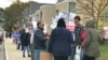 Lowell residents stand by a polling station with banners supporting their candidates on election day in Lowell, Massachusetts, November 7, 2017. (Courtesy photo of Sidney Liang)