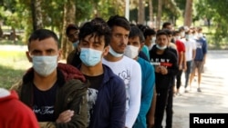 FILE - Afghan migrants are seen at a camp in Obrenovac, near Belgrade, Serbia, Aug. 31, 2021. 