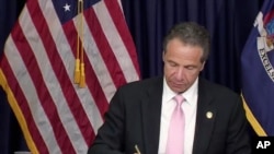 FILE - In this photo made from video provided by the office of New York Governor Andrew M. Cuomo, Gov. Cuomo, signs into law, June 12, 2020, in New York, a sweeping package of police accountability measures.