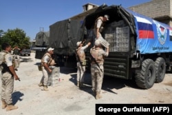 SYRIA -- Russian soldiers unpack aid, from Russia and the Chechen Ahmed Kadyrov fund, in the northern Syrian town of Tal Rifaat, August 8, 2018