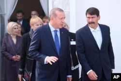 Turkish President Recep Tayyip Erdogan, left, chats with Hungarian President Janos Ader as he steps out on the terrace of the presidential Alexander Palace in Budapest, Hungary, Oct. 8, 2018.