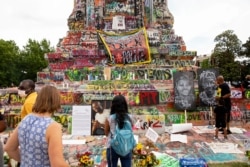 People gather around the Robert E. Lee statue on Monument Avenue in Richmond, Va., June 20, 2020. The global civil unrest ignited by Floyd's death has left many Americans questioning their country's racist past.