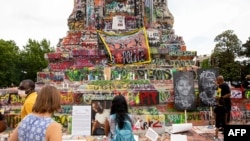 People gather around the Robert E. Lee statue on Monument Avenue in Richmond, Va., June 20, 2020. The global civil unrest ignited by George Floyd's death has left many Americans questioning their country's racist past.