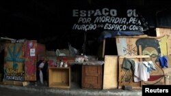 A woman sits in front of her home which was built under a bridge in downtown Sao Paulo, Brazil, March 3, 2016. 