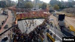People form a "V" for "vote" in red and yellow, colors of the Catalan flag, to mark "Diada," central Barcelona, Sept. 11, 2014.