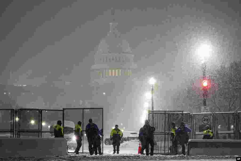 Law enforcement officers stand guard at the Capitol as snow falls ahead of a joint session of Congress to certify the votes from the Electoral College in the presidential election, in Washington, Jan. 6, 2025. 