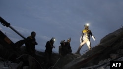 FILE - Members of the Syrian Civil Defence, also known as the White Helmets, search for survivors following an airstrike on the flashpoint town of Maaret al-Numan in Syria's northwestern Idlib governorate, Dec. 30, 2019. 