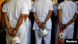 FILE - Members of the MS-13 cartel wait to board a bus to be transferred from the Chalatenango penitentiary, in Chalatenango, El Salvador, Dec. 27, 2019. 