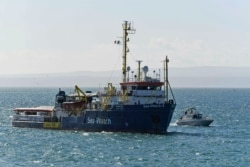 The migrant rescue ship Sea-Watch 3, carrying 47 migrants, is escorted by an Italian police boat as it makes its way into the Sicilian port of Catania, southern Italy, Jan. 31, 2019.