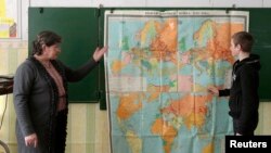 FILE - A teacher leads a history lesson for seventh graders in the Russian village of Bolshie Khutora, about 440 km west of Moscow.