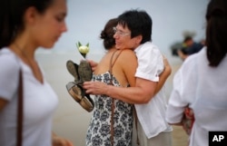 Relatives of the Asian tsunami's victims comfort each other during a commemoration for Germans, Austrians and Swiss killed in Khao Lak, Thailand, Dec. 26, 2014.