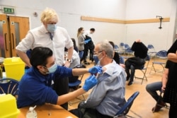 British Prime Minister Boris Johnson visits Stow Health vaccination center in Westminster, London, Britain, Dec. 13, 2021.