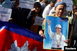 FILE - Supporters of Kem Sokha, leader of the Cambodia National Rescue Party, stand outside the Appeal Court during a bail hearing for the jailed opposition leader in Phnom Penh, Cambodia, Sept. 26, 2017.