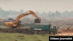 ລົດຈົກຂົນດິນຂຶ້ນລົດຖອກດິນ ໃນໂຄງການນຶ່ງຢູ່ປະເທດ ລາວ.