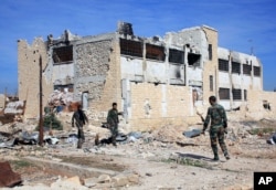 FILE - This Wednesday, Nov. 11, 2015, file photo released by the Syrian official news agency SANA, shows Syrian government troops walk inside the Kweiras air base, east of Aleppo, Syria.