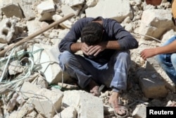 A man whose relatives were killed in an airstrike grieves amid rubble in the rebel-held al-Qaterji neighborhood of Aleppo, Syria, Oct. 11, 2016.