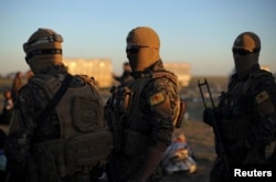 Fighters of Syrian Democratic Forces (SDF) stand together near the village of Baghouz, Deir Al Zor province, Syria March 1, 2019.