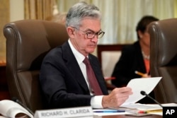 FILE - Federal Reserve Chair Jerome Powell looks over papers during a meeting at the Fed's offices in Washington, Oct. 31, 2018.