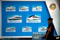 រូបឯកសារ៖ បុគ្គលិក​សន្តិសុខ​ម្នាក់​ដើរក្បែរ​ផ្ទាំង​បង្ហាញ​ពី​គំរូ​រថភ្លើង​ល្បឿន​លឿន​របស់​ចិន នៅ​មុន​កិច្ច​ប្រជុំ​វេទិកា​សហប្រតិបត្តិការ​ចិន-អាហ្វ្រិក​នៅ​រដ្ឋធានី​ប៉េកាំង​របស់​ចិន​ កាល​ពី​ថ្ងៃ​ទី​៣០ ខែ​សីហា ឆ្នាំ​២០១៨។