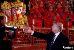 President Donald Trump shakes hands with opera performers at the Forbidden City in Beijing, China, Nov. 8, 2017.