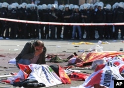 A man cries over the body of a victim, at the site of an explosion in Ankara, Oct. 10, 2015.