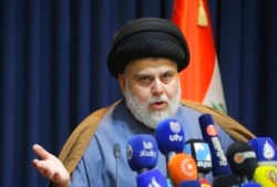FILE - Populist Shiite cleric Moqtada al-Sadr speaks during a press conference in Najaf, Iraq, Nov. 18, 2021.