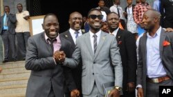 FILE - Ugandan pop star Kyagulanyi Ssentamu, better known as Bobi Wine, center, leaves shortly after being sworn in as a member of parliament in Kampala, Uganda, July 11, 2017. The 36-year-old urges his countrymen to stand up against what he calls a failing government but was charged, Aug. 16, 2018, in a military court over his alleged role in clashes in the northwestern town of Arua where both he and President Yoweri Museveni were campaigning.